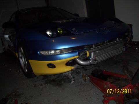 1995 Ford Probe - A modified 1995 Ford Probe with a custom front bumper and exposed intercooler is shown in a garage.