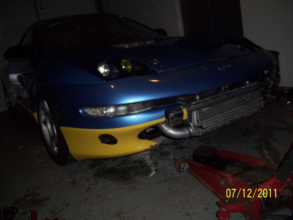 Blue and yellow car, front view, with exposed intercooler and yellow fog lights