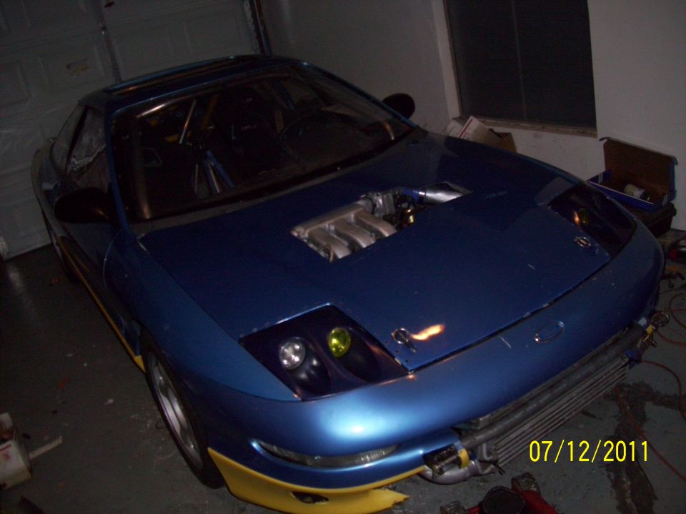 Blue 1995 Ford Probe with yellow trim and exposed engine