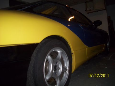 1995 Ford Probe - Car with yellow and blue paint scheme and a silver wheel is shown from the side.