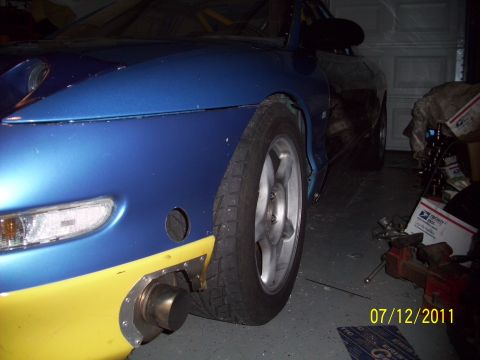 1995 Ford Probe - A blue and yellow car is shown with a custom exhaust pipe modification visible on the front fender.