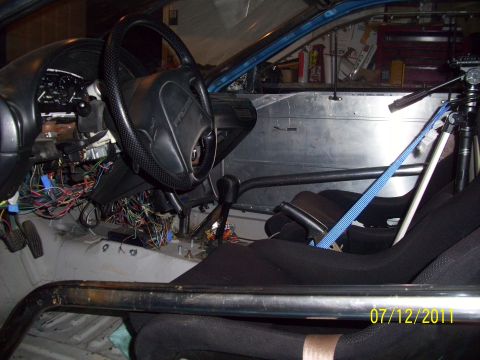1995 Ford Probe - The interior of a car shows racing seats, a roll cage, and extensive exposed wiring, suggesting a custom build or modification.