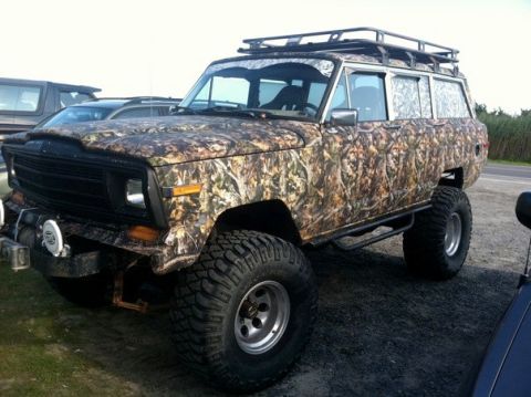 1995 Ford Bronco - This lifted Jeep Grand Wagoneer is covered in a camouflage wrap and has a roof rack.