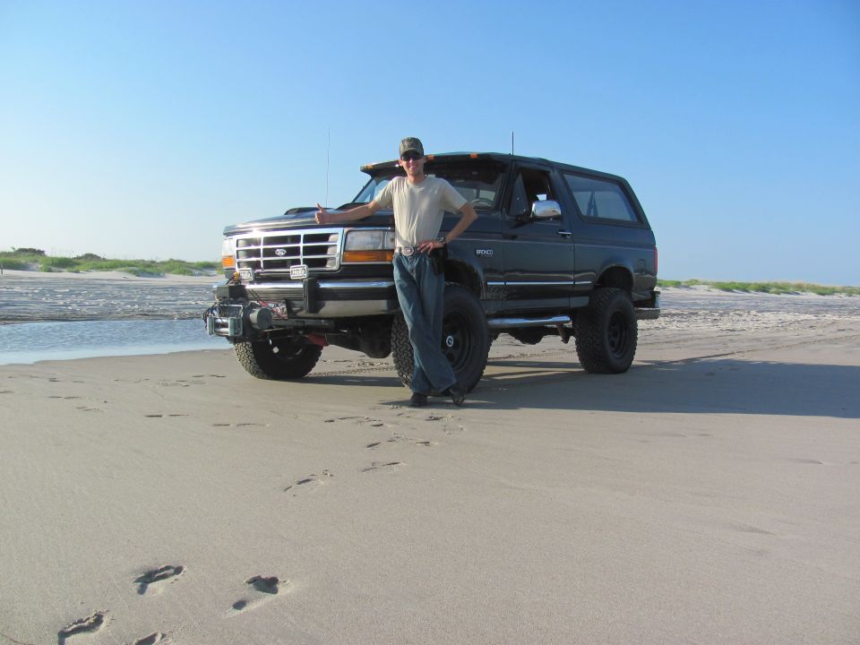 Black 1995 Ford Bronco on a sandy beach