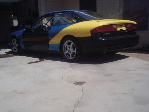 1995 Ford Probe - This car has a unique paint scheme and visible rivets along the top edge of the body panels.