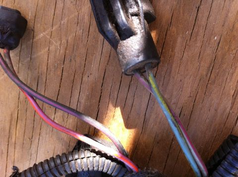 1990 Ford Bronco II - A close-up view of a wiring harness connector with several colored wires is shown against a wooden background.
