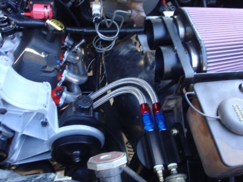 1989 Ford Bronco - Close-up view of an engine bay braided hoses and an aftermarket air filter, suggesting performance modifications.