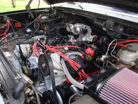 1989 Ford Bronco - Custom engine bay with performance modifications visible, including dual throttle bodies and a K&N air filter.