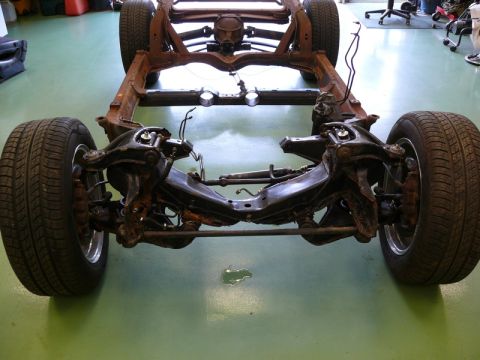 1976 Chevrolet Corvette - The chassis and suspension system of a car, with wheels mounted, is shown in this image.