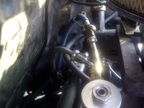 1994 Ford F-150 - Close-up view of a fuel line assembly within a vehicle's engine bay, various metal connectors and blue tubing.