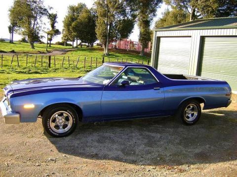 1973 Ford Ranchero - This two-tone blue Ford Ranchero is parked outside a garage on a sunny day.