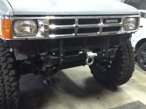 1988 Suzuki Samurai - Front view of a Toyota truck, likely from the late 1980s, with a winch mounted on the bumper.