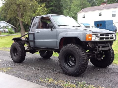 1988 Suzuki Samurai - This modified pickup truck features oversized tires and a flatbed conversion, differing from the claimed Suzuki Samurai.