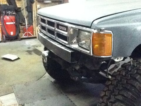 1988 Suzuki Samurai - Close-up of a Toyota truck's front end, a chrome grille and amber turn signals.