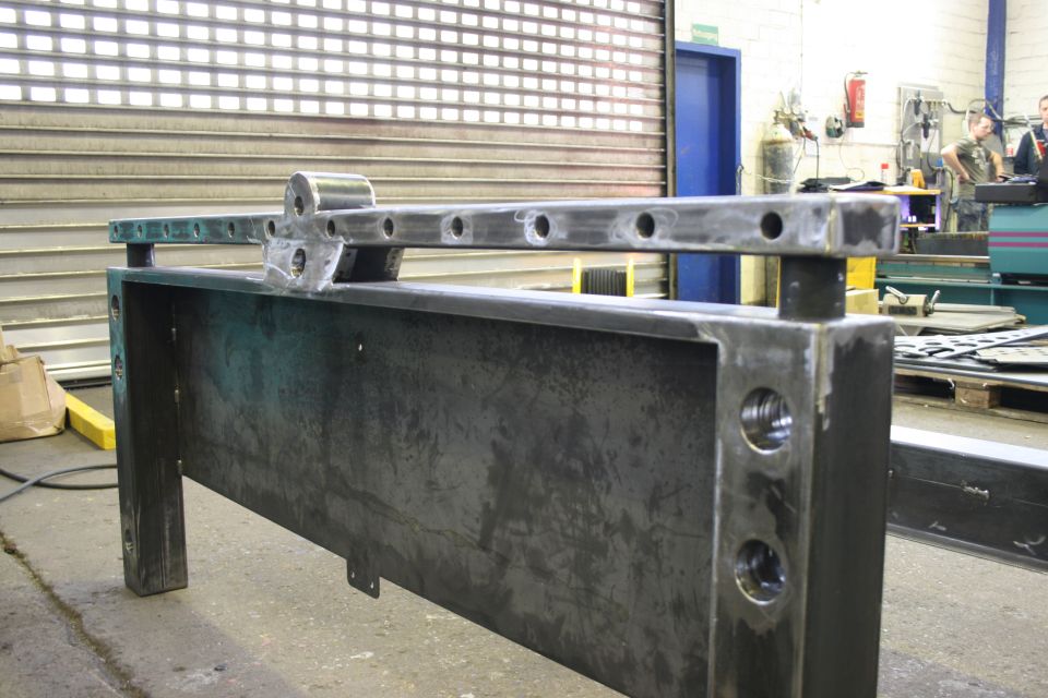 fabricated metal frame with holes and brackets in workshop