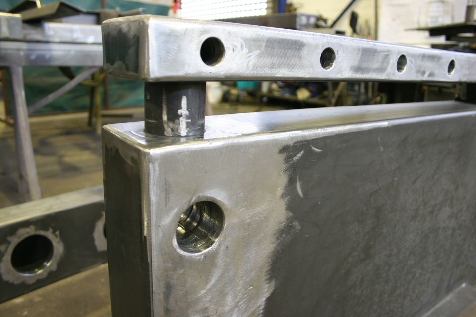 Metal frame with drilled holes and a cylindrical post inserted