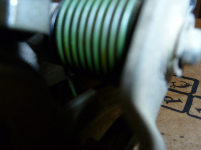 Green wire coil with white casing and cardboard with text