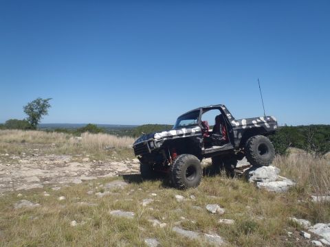 1979 Ford Bronco - Modified 1979 Ford Bronco navigating rocky terrain under a clear blue sky.