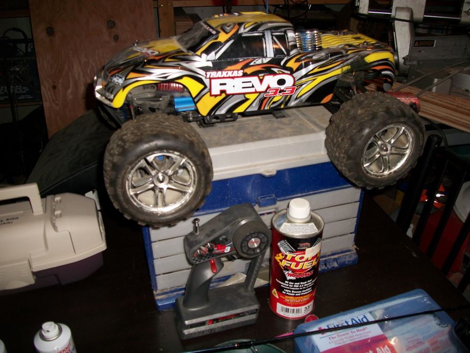 Yellow and black Traxxas Revo 3.3 RC monster truck with large tires and a remote control