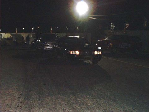 2000 Ford Crown Victoria - A 2000 Ford Crown Victoria is seen at a drag strip at night, with other vehicles present.