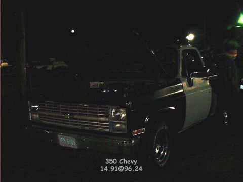 2000 Ford Crown Victoria - A two-tone pickup truck is seen at night with its hood open, showing a front quarter view.