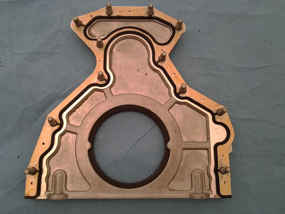 Close-up of a metal engine timing cover gasket with a rubber seal