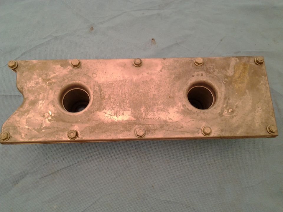 Aluminum engine part with two cylindrical openings and visible bolt heads