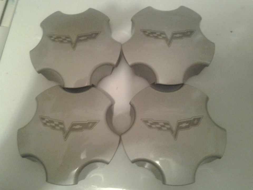 Four gray wheel center caps with Corvette flags emblem