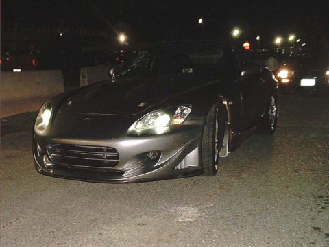 2000 Ford Crown Victoria - A Honda S2000 is parked on asphalt at night, with lights in the background.