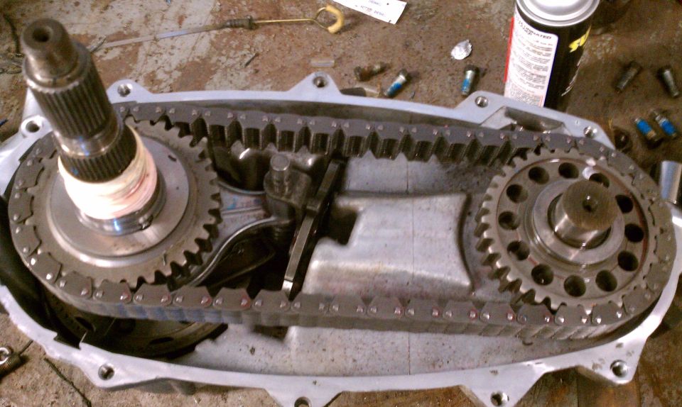 Transfer case with chain and gears exposed. Shaft with splines on left