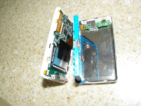 1994 Ford Bronco - An electronic device is disassembled, revealing its internal components and battery.