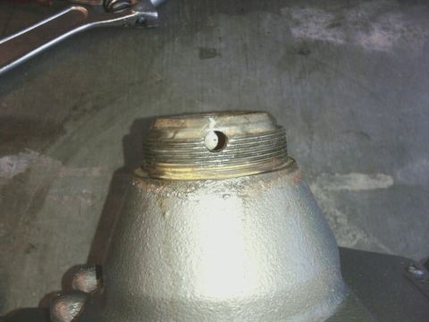 1995 Ford Bronco - A close-up view of a threaded metal component, likely a vehicle part, with a small hole visible on its surface.