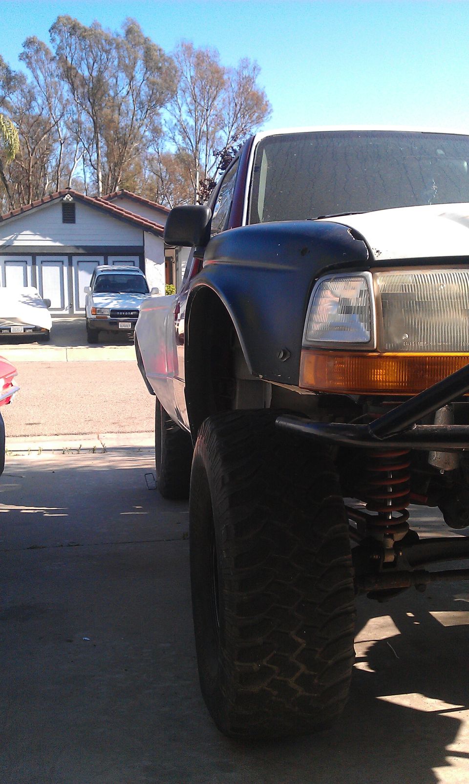 1992 Ford Ranger pickup truck with aftermarket suspension and large tires, parked in driveway