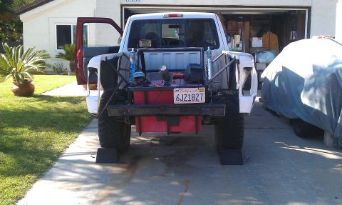 1992 Ford Ranger - This truck has a custom bed setup with a large fuel tank and roll cage, parked next to a covered vehicle.
