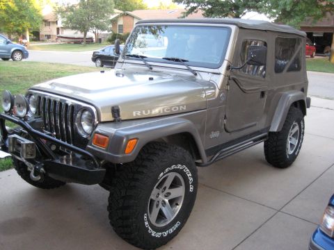 2005 Jeep Wrangler - This Jeep Wrangler Rubicon is parked in a suburban driveway with a soft top and off-road tires.