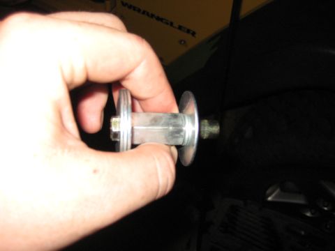 2005 Jeep Wrangler - A person is holding a metal component with a bolt and two flanges.