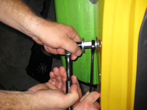2005 Jeep Wrangler - Hands are shown attaching a metal bracket to a yellow and green object with tools.