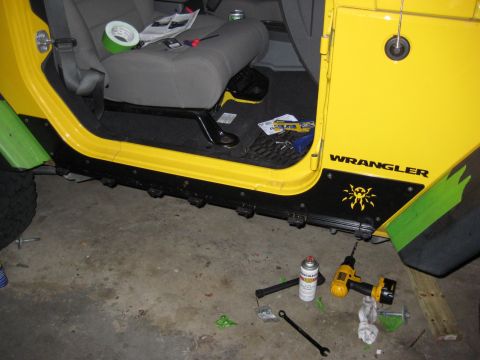 2005 Jeep Wrangler - The interior side of a yellow 2005 Jeep Wrangler is visible, with tools and supplies scattered on the floor, suggesting ongoing work.