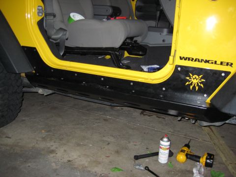 2005 Jeep Wrangler - Side view of a 2005 Jeep Wrangler's interior, highlighting the yellow exterior and installed black rock sliders.