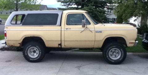 2006 Ford E350 - This pickup truck has a camper shell and is equipped with off-road tires.