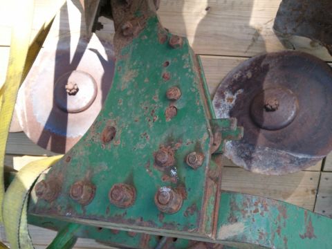 1985 Ford F-150 - Close-up of a rusty green agricultural implement part with visible bolts and discs.