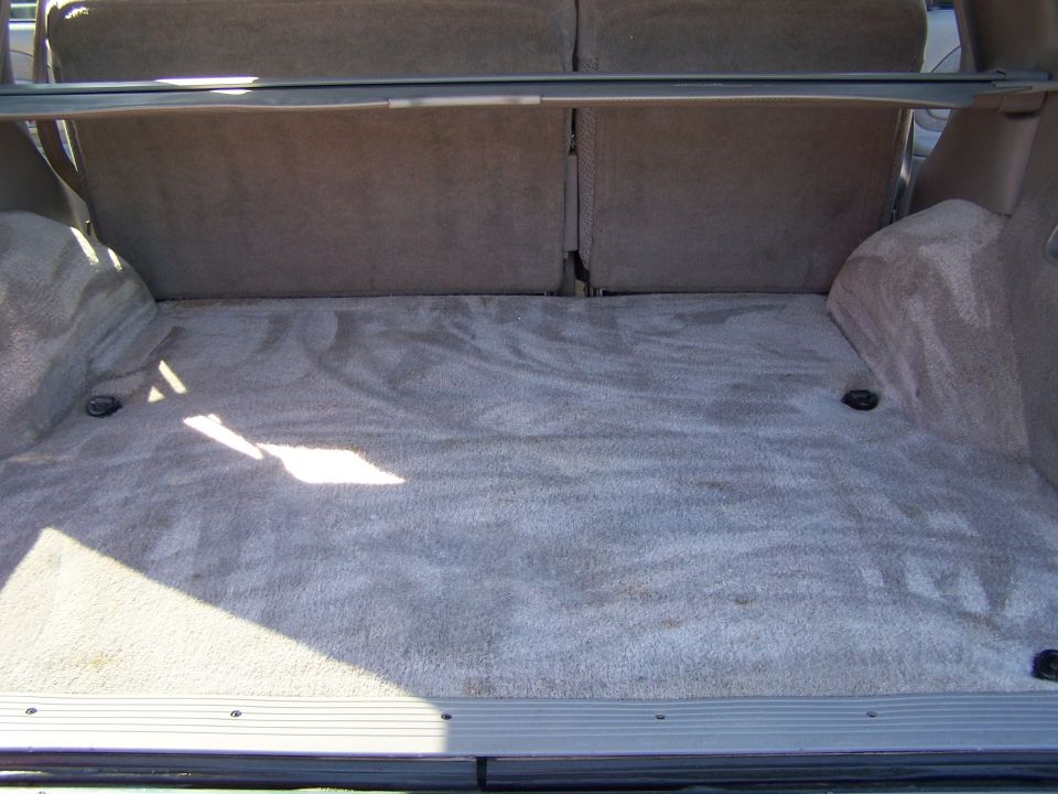 Cargo area of an SUV with carpeted floor and seats folded down