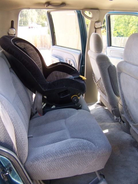 1995 Chevrolet Tahoe - The interior of a 1995 Chevrolet Tahoe shows the back seat with a car seat installed.