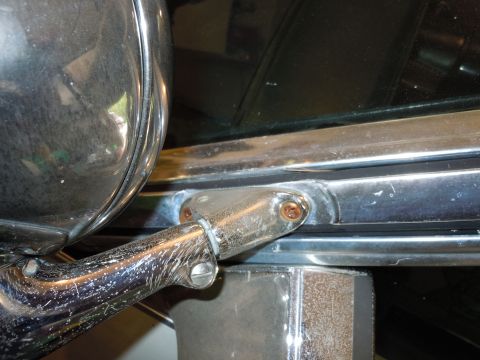 2001 Ford Crown Victoria - Close-up of a weathered chrome side mirror mount on a 2001 Ford Crown Victoria.