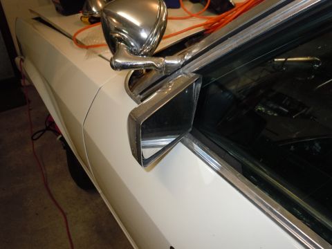 2001 Ford Crown Victoria - Close-up of a chrome side mirror on a white vehicle, with reflections visible.
