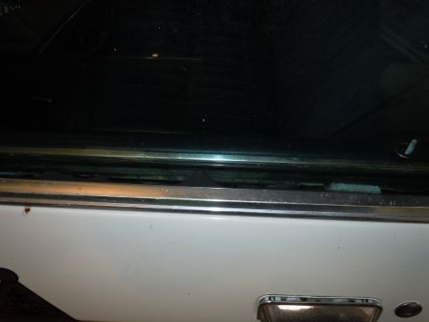 2001 Ford Crown Victoria - Detail shot of a car's door handle and window trim.