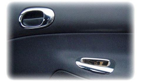 1991 Ford LTD Crown Victoria - Close-up of a car's interior door panel showing chrome door handles and black textured material.