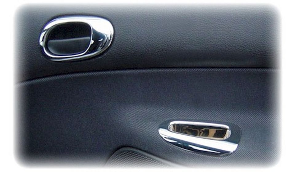 Interior car door panel with two chrome door handles and textured black trim