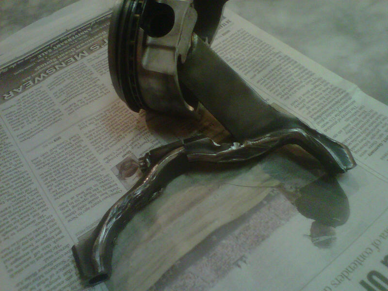 Engine piston and connecting rod on newspaper