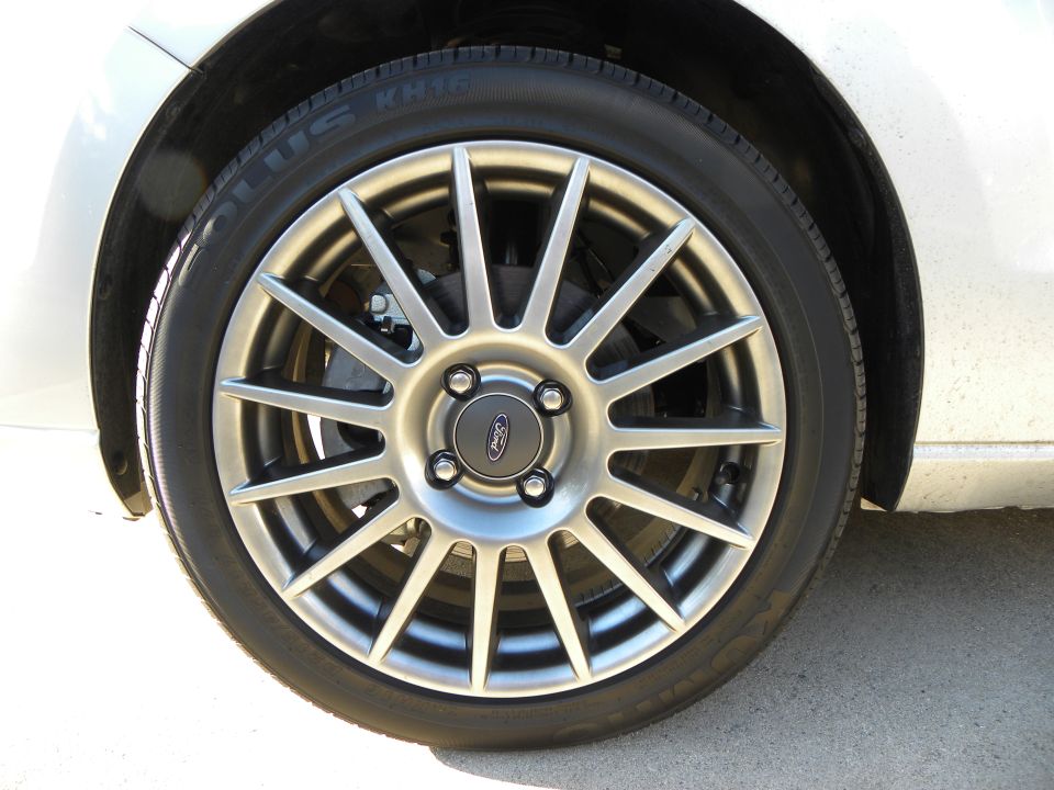Silver 2010 Ford Focus wheel with a Ford badge on the center cap